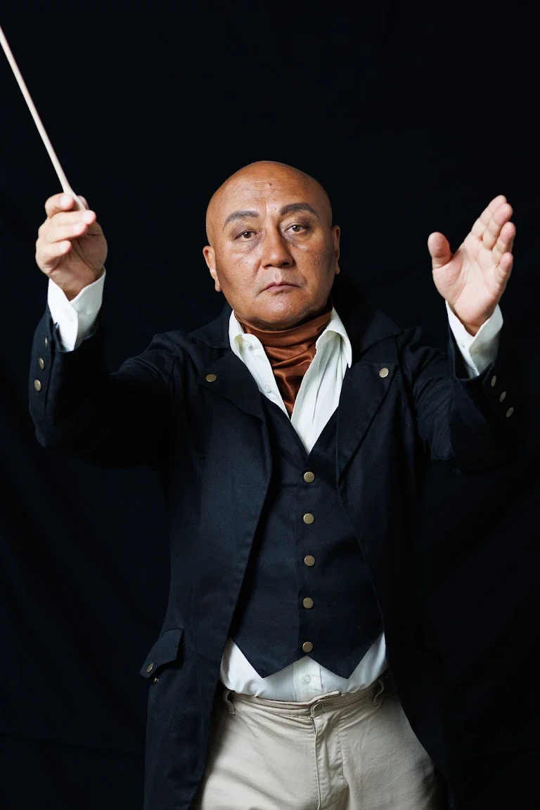 The conductor raises his baton