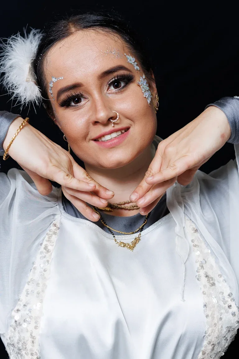 A performer in white, adorned with flowers